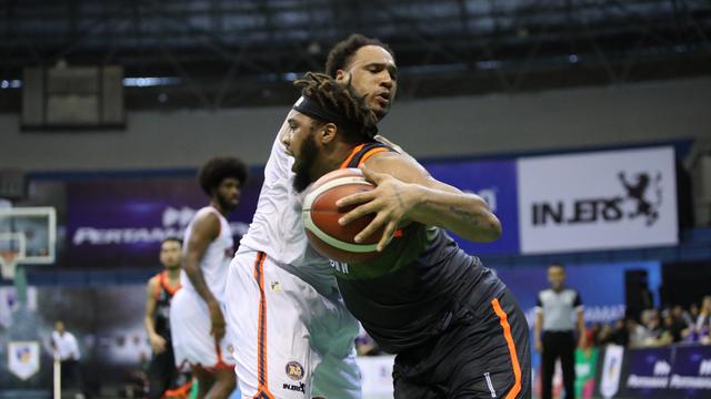 Pemain Pelita Jaya Dior Lowhorn berduel dengan center NSH Michael Glover