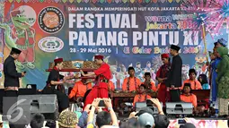 Aksi palang pintu saat Festival Palang Pintu 2016 di Kemang, Jakarta, (28/5). Festival tersebut menampilkan budaya Betawi di sepanjang Jalan Kemang Raya dengan dua panggung utama dan sekitar 270 booth. (Liputan6.com/Immanuel Antonius)