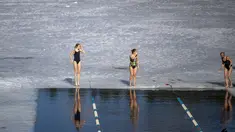 Para perenang bersiap bertanding dalam kompetisi renang musim dingin di lubang es sepanjang 25 meter di danau dekat Vilnius, Lithuania, Sabtu (6/3/2021).  Suhu air saat itu 3 derajat Celcius, sedangkan udaranya -3 derajat Celsius. (AP Photo/Mindaugas Kulbis)