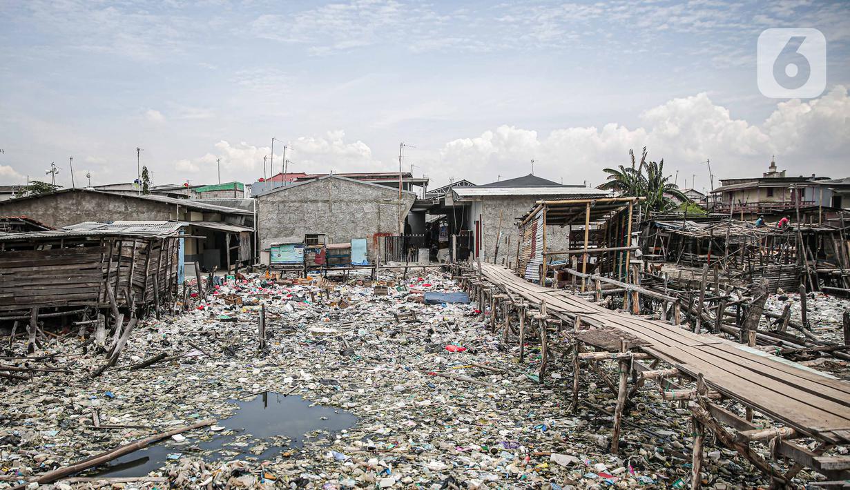 Suasana jembatan kayu di antara sampah di perkampungan nelayan Cilincing, Jakarta, Minggu (21/2/2022). Peringatan HPSN 2022, Pemprov DKI Jakarta mengajak warga Jakarta untuk peduli sampah mulai dari lingkungan terdekat minimal dengan cara memilah sampah dari rumah. (Liputan6.com/Faizal Fanani)