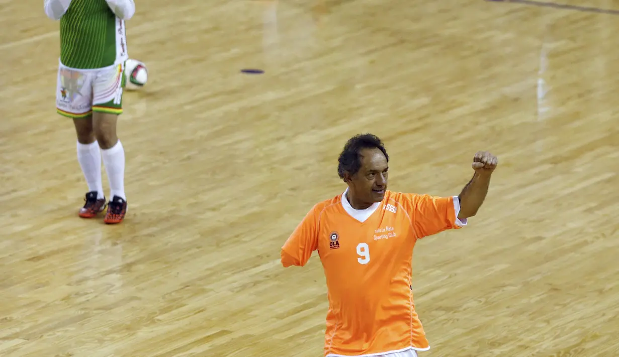 Calon Presiden Argentina, Daniel Scioli (kiri) melakukan selebrasi usai mencetak gol saat pertandingan melawan tim Presiden Bolivia di Benavidez, Buenos Aires, Argentina (17/9/2015). (REUTERS/Marcos Brindicci)