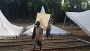 Pekerja mengangkat papan untuk menyelesaikan tenda relawan di Jalan Setiabudi, Medan, Senin (20/11). Menurut petugas bagian dekorasi, ada banyak tenda yang dipasang di 3 titik berbeda, seperti untuk tamu VIP, dan lokasi resepsi. (Liputan6.com/Aditya Eka)