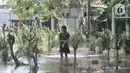 Warga melintasi banjir yang merendam makam di Pulo Nangka, Kelurahan Kayu Putih, Kecamatan Pulogadung, Jakarta, Minggu (23/2/2020). Selain permukiman, banjir merendam ribuan makam di Pulo Nangka hingga ketinggian mencapai 70 cm. (merdeka.com/Iqbal S. Nugroho)