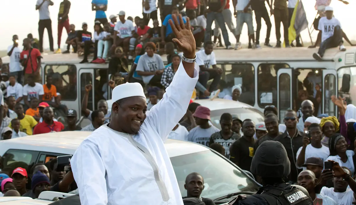 Presiden baru Gambia, Adama Barrow melewati kerumunan rakyat yang menyambutnya di bandara Banjul, Kamis (26/1). Barrow akhirnya pulang ke negaranya untuk melanjutkan kekuasaan setelah pemimpin sebelumnya, Yahya Jammeh, pergi. (AP Photo/Jerome Delay)