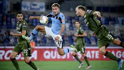 Penyerang Lazio, Ciro Immobile, berebut bola dengan bek Cagliari, Ragnar Klavan, pada laga lanjutan Serie A pekan ke-35 di Stadio Olimpico, Jumat (24/7/2020) dini hari WIB. Lazio menang 2-1 atas Cagliari.(AFP/Filippo Monteforte)