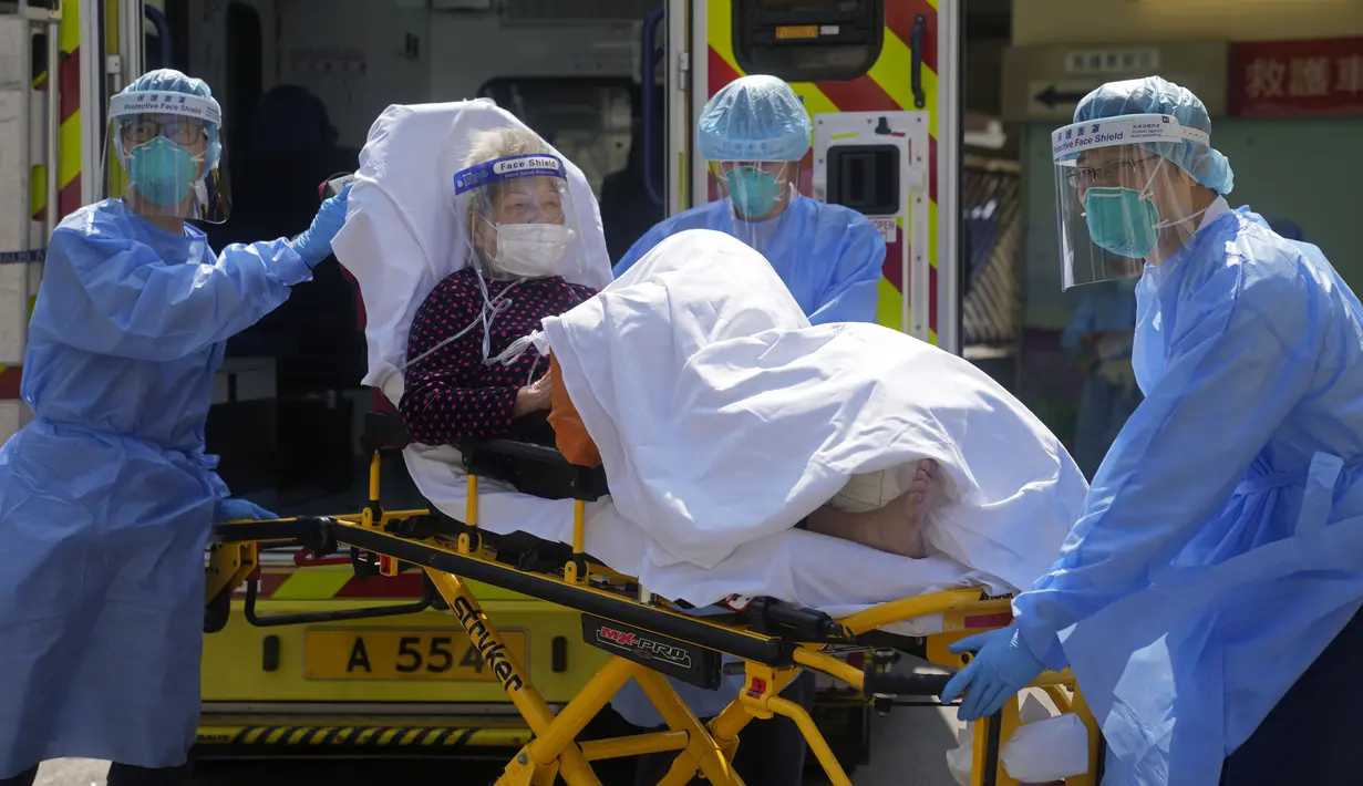 Pekerja medis memindahkan seorang pasien lanjut usia dari ambulans menuju rumah sakit di Hong Kong, Jumat (4/3/2022). Pemimpin Hong Kong awal pekan ini mengatakan mobilitas orang mungkin dibatasi selama tes covid-19 massal wajib ketika kasus harian mencapai rekor. (AP Photo/Kin Cheung)