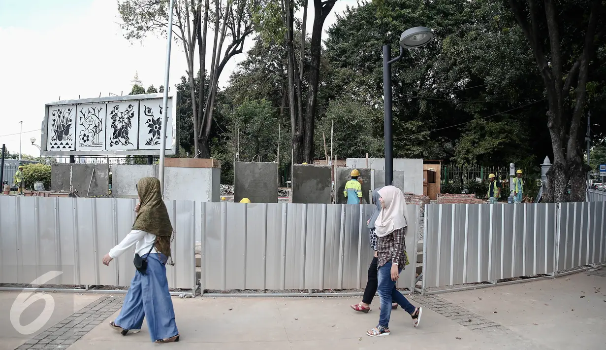 Sejumlah warga melintas di depan proyek pembangunan Taman Aspirasi Monas di seberang Istana Presiden, Jakarta, Kamis (2/6).  Taman tersebut ditargetkan akan bertepatan dengan HUT ke-489 Kota Jakarta, 22 Juni 2016 mendatang. (Liputan6.com/Faizal Fanani)