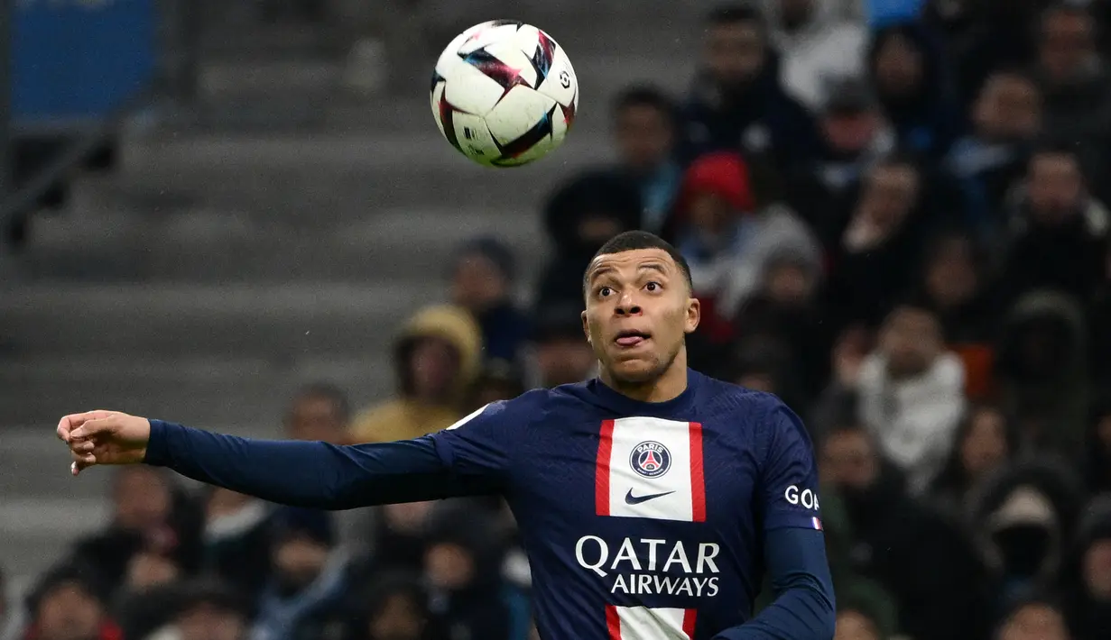 Penyerang Paris Saint-Germain (PSG) Kylian Mbappe menatap bola saat menghadapi Olympique Marseille dalam laga pekan ke-25 Liga Prancis 2022-2023, di Stadion Velodrome pada Senin (27/2/2023) dini hari WIB. Kylian Mbappe menjadi bintang utama dalam kemenangan PSG setelah dirinya mampu mencetak dua gol dan satu assist untuk Lionel Messi.  (CHRISTOPHE SIMON / AFP)