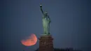 Pemandangan ketika Patung Liberty dihiasi oleh supermoon di Brooklyn, New York, Amerika Serikat, Rabu (31/1). Namun demikian, hanya sebagian gerhana yang terlihat di Pantai Timur Amerika. (AP Photo/Julio Cortez)