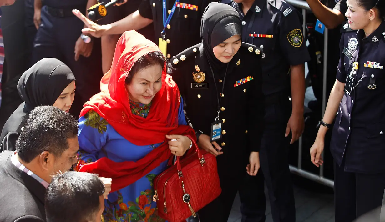 Istri mantan Perdana Menteri Malaysia Najib Razak, Rosmah Mansor dikawal petugas saat memenuhi panggilan Komisi Antikorupsi Malaysia (MACC) di Putrajaya, Selasa (6/5). Rosmah tampak tenang turun dari mobil dan berjalan ke kantor MACC. (AP/Vincent Thian)