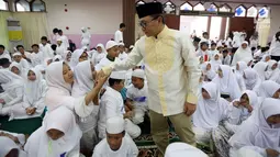 Ketua MPR Zulkifli Hasan menyalami anak-anak saat acara Tadarus dan Katham Al Quran bersama anak Yatim di Aula Masjid Baiturahman Komplek MPR/DPR RI, Jakarta, Minggu (11/6). Acara tersebut di hadiri kurang lebih 1500 Anak Yatim. (Liputan6.com/JohanTallo)