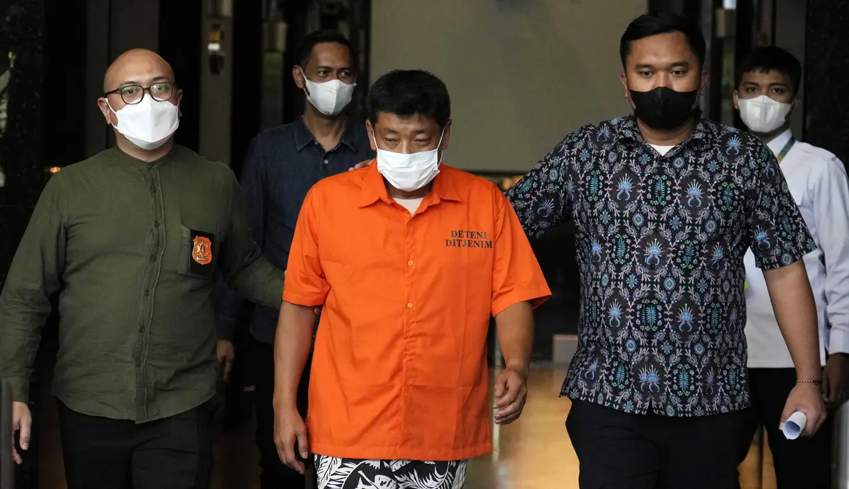Petugas imigrasi mengawal Mitsuhiro Taniguchi (47) sebelum konferensi pers di Kantor Imigrasi, Jakarta, Indonesia, Rabu (8/6/2022). Buronan Jepang tersebut dituduh melakukan penipuan di Jepang terkait penerimaan subsidi COVID-19 dalam jumlah besar untuk usaha kecil yang kesusahan. (AP Photo/Achmad Ibrahim)