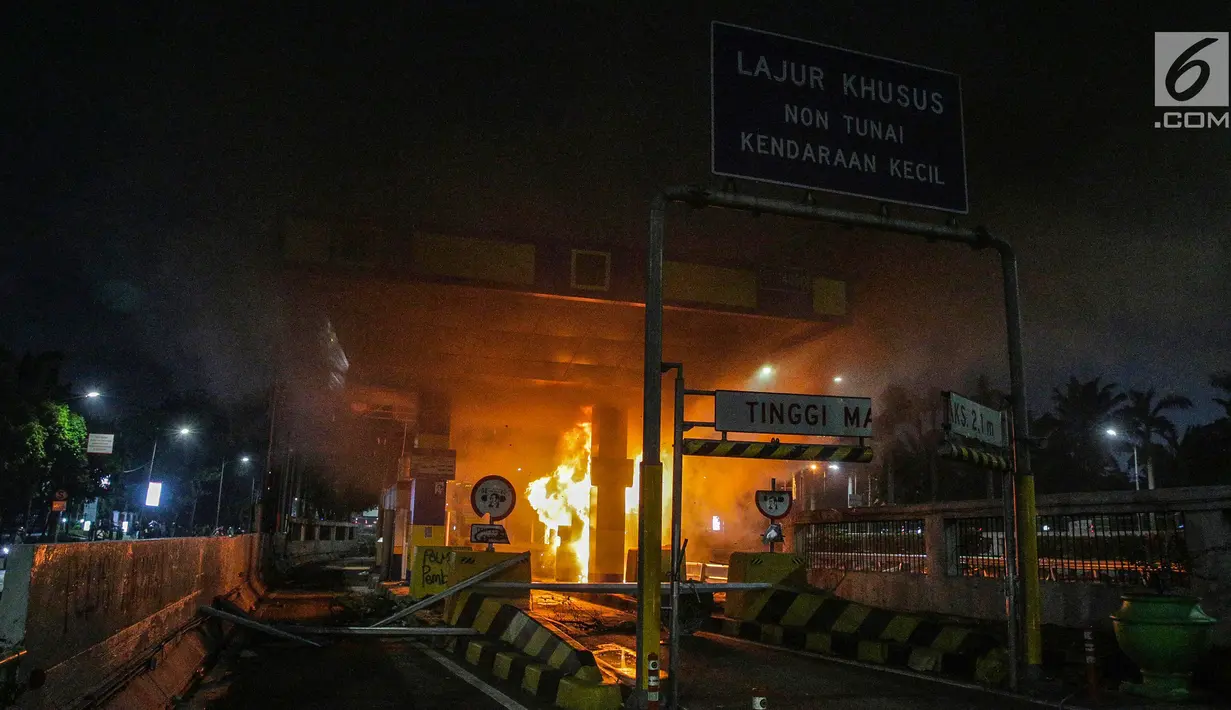 Gardu Tol Pejompongan 1 dibakar massa saat demonstrasi mahasiswa di depan Gedung DPR/MPR, Jakarta, Selasa (24/9/2019). Demonstrasi mahasiswa berujung ricuh, polisi menembakkan gas air mata dan water cannon untuk membubarkan demo. (Liputan6.com/Faisal Fanani)