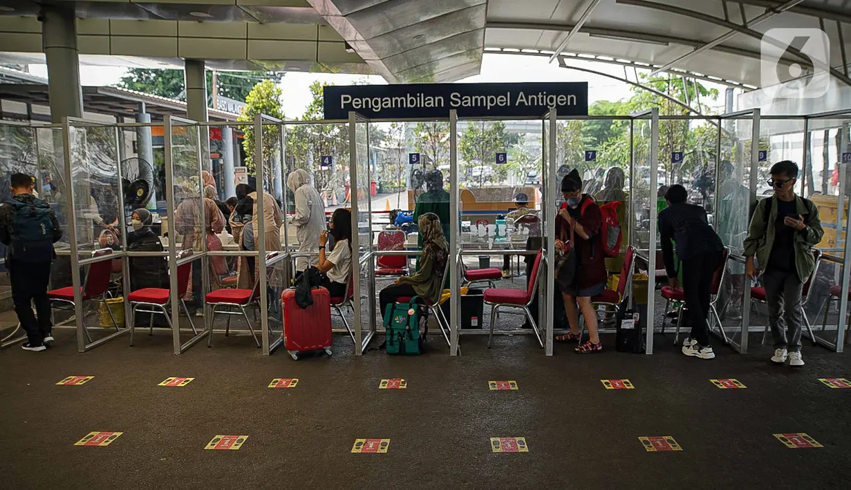 Sejumlah calon penumpang menjalani tes swab PCR di Stasiun Pasar Senen, Jakarta, Jumat (24/12/2021). PT Kereta Api Indonesia (Persero) atau KAI menghadirkan layanan tes PCR seharga Rp 195.000 di sejumlah stasiun selama periode Natal dan Tahun Baru mulai 23 Desember 2021. (Liputan6.com/Faizal Fanani)