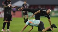 Pengawal Lionel Messi, Yassine Cheuko terjatuh saat berusaha menangkap seorang penyusup lapangan dalam laga persahabatan antara Inter Miami melawan Sporting San Miguelito di Stadion Romeo Fernandez, Panama, Amerika, Senin (03/02/2025) waktu setempat. (AP Photo/Matias Delacroix)