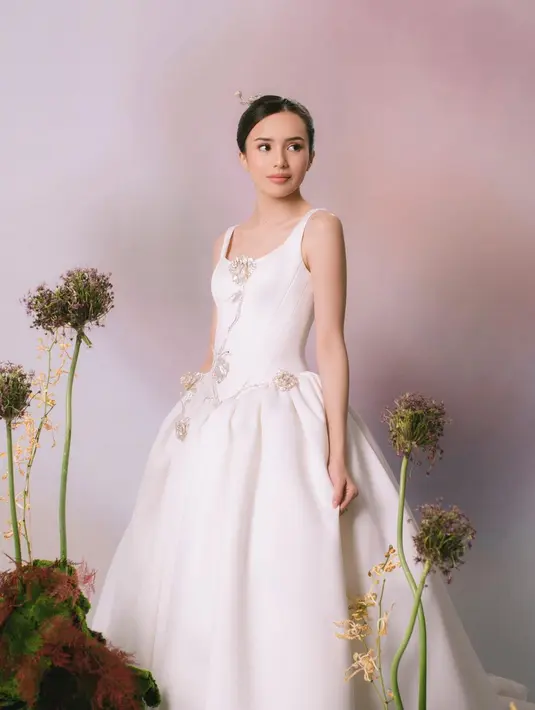 Sebuah gaun putih dengan detail garis leher yang dalam dan aksesori super cantik berupa bros berkilauan di bagian depan gaun, mempercantik penampilan Beby Tsabina secara keseluruhan, tanpa menimbulkan kesan berlebihan. [Foto: Instagram/bebytsabina]