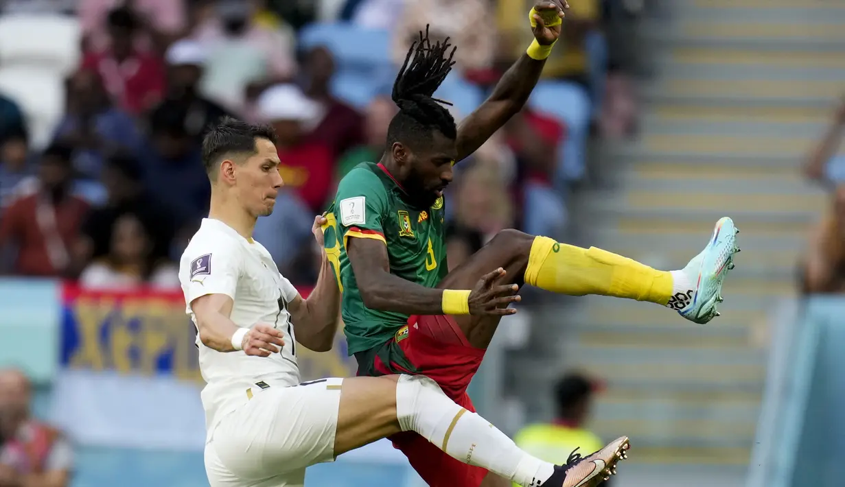 Gelandang Kamerun Andre-Frank Zambo Anguissa berebut bola dengan gelandang Serbia Sasa Lukic pada matchday 2 Grup G Piala Dunia 2022 di Al Janoub Stadium, Senin (28/11/2022). Serbia tidak melakukan banyak perubahan susunan pemain saat menghadapi Kamerun di laga kedua Piala Dunia Qatar.  (AP Photo/Manu Fernandez)