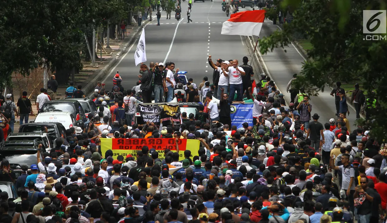 Iring-iringan driver taksi online saat aksi unjuk rasa di depan Kantor Kementrian Perhubungan, Jakarta Pusat, Senin (29/1). Aturan yang diprotes mengenai pembentukan koperasi, pembuatan SIM A umum dan uji KIR kendaraan. (Liputan6.com/Angga Yuniar)