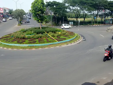 Aktivitas lalulalang kendaraan roda dua dan empat terlihat lengang pada hari ketiga penerapan Pembatasan Sosial Berskala Besar (PSBB) di Bundaran Ciater, Tangerang Selatan, Banten, Senin (20/04/2020). (merdeka.com/Dwi Narwoko)