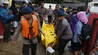 Polisi mengevakuasi jenazah korban gelombang Tsunami Anyer di Puskesmas Carita, Banten, Minggu (23/12). BNPB mencatat ratusan orang meninggal dunia dan ratusan luka-luka. (Liputan6.com/Angga Yuniar)
