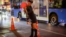 Seorang anggota komunitas LGBTQ berpose untuk berfoto di jalan yang didekorasi untuk menyambut Tahun Baru Imlek di Chinatown Bangkok (9/2/2021). (AFP/ Mladen Antonov)