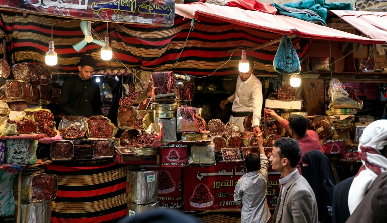 Sejumlah pedagang kurma menunggu pembeli di sebuah pasar di kota tua Sanaa, Yaman, Sabtu (11/5/2019). Kurma menjadi salah satu pilihan umat muslim sebagai menu buka puasa di bulan suci Ramadan. (Photo by Mohammed HUWAIS / AFP)