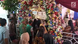 Warga antre memberikan hak suaranya di TPS 09 Kelurahan Sambirejo yang berkonsep pesta pernikahan di Semarang, Jawa Tengah, Rabu (17/4). TPS itu dihiasi dengan dekorasi mewah dan menarik layaknya tempat pesta pernikahan agar semua warga senang ketika datang untuk mencoblos. (Liputan6.com/Gholib)