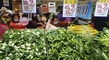 Pelanggan mengenakan masker, membeli sayuran segar di toko pasar basah di Hong Kong, Rabu, 9 Februari 2022. Hong Kong memberlakukan langkah-langkah jarak sosial yang paling ketat untuk mempertahankan kebijakan nol COVID-19 di tengah lonjakan kasus yang dipicu Varian Omicron. (AP Photo/Vincent Yu)