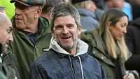 Noel Gallagher tersenyum di hadapan penonton saat pertandingan Liga Inggris antara Liverpool dan Manchester City di Anfield di Liverpool, barat laut Inggris pada 11 Oktober 2026. (Paul ELLIS/AFP)