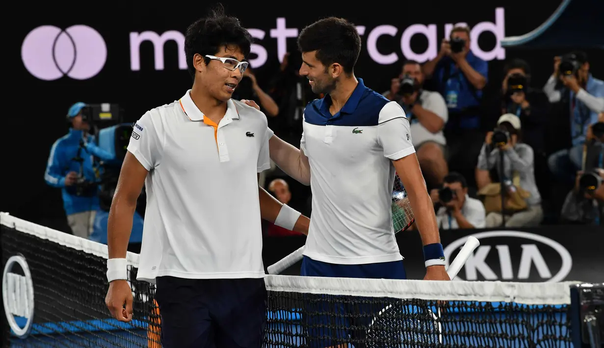 Petenis Korea Selatan Chung Hyeon berbincang usai mengalahkan petenis Serbia, Novak Djokovic pada putaran keempat kejuaraan tenis Australia Terbuka di Melbourne (22/1). Chung Hyeon menang 6-7(4), 5-7, 6-7(3). (AFP Photo/Paul Crock)