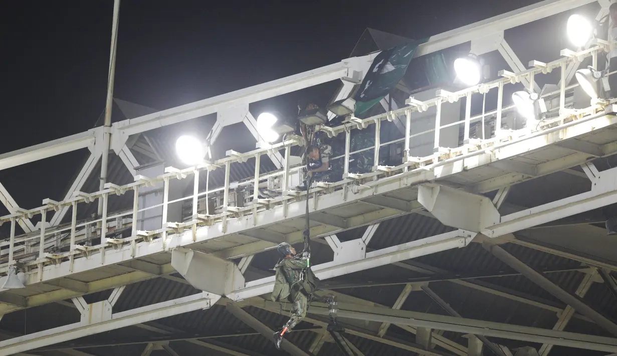 Dengan penuh keberanian seorang penerjun yang tersangkut berusaha naik menuju atap stadion. (Bola.com/Vitalis Yogi Trisna)