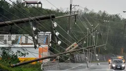 Kendaraan melintas disamping tiang listrik yang roboh akibat hantaman topan super Meranti di  Taiwan selatan, Rabu (14/9). Selain angin kencang, Topan Meranti dikhawatirkan bisa memicu hujan deras dan banjir di sekitar wilayah Taiwan. (Sam YEH/AFP)