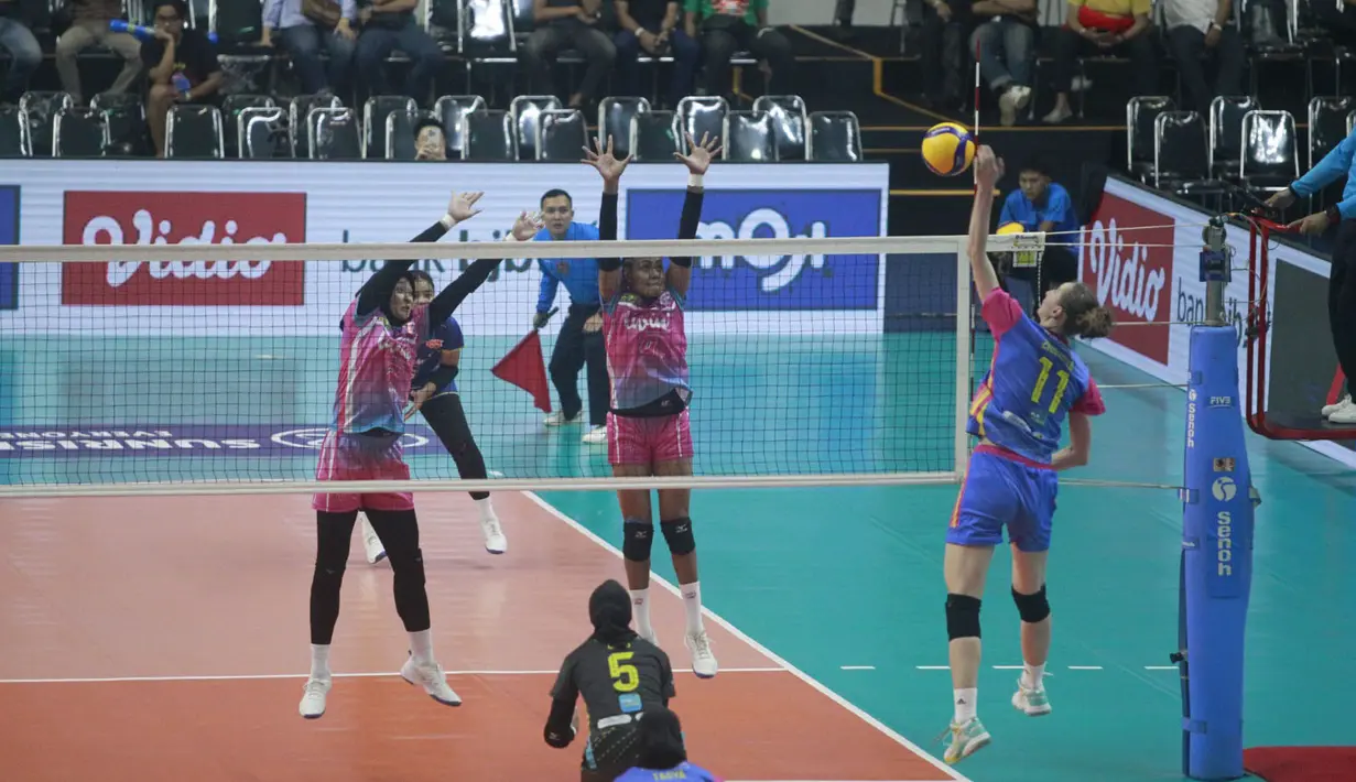 <p>Pemain Jakarta Electric PLN, Katerina Zhidkova (kanan) melepaskan spike yang berusaha diblok dua pemain Jakarta Livin Mandiri, Pascalina Mahuze (tengah) dan Afra Hasna Nurhaliza pada laga seri kedua putaran kedua PLN Mobile Proliga 2024 di GOR Si Jalak Harupat, Kabupaten Bandung, Jumat (7/6/2024). Jakarta Electric PLN menang 3-0 (25-19, 25-22, 26-24). (Dok. PBVSI)</p>