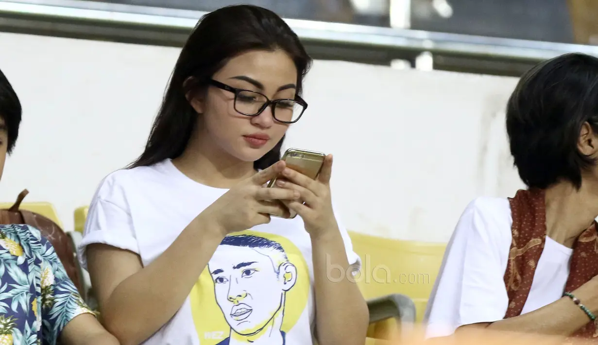 Ariel Tatum tengah serius melihat handphone saat berada di tribun VIP menyaksikan laga Persija Jakarta melawan Sriwijaya FC di Stadion Wibawa Mukti, Cikarang, Jumat (16/6/2017). (Bola.com/Nicklas Hanoatubun)
