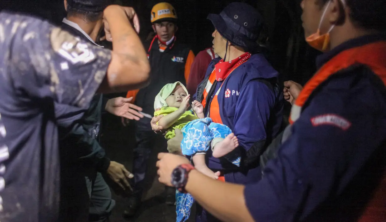 Tim penyelamat mengevakuasi balita di tengah banjir akibat hujan deras di Medan, Sumatera Utara (4/12/2020). Meluapnya air Sungai Sunggal yang menjadi pembatas antara Kabupaten Deli Serdang dengan Kota Medan, Sumatera Utara, menyebabkan ratusan rumah warga terendam banjir. (AFP/Albert Ivan Damanik)