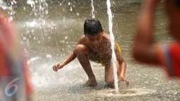 Seorang anak bermain air di Taman Kodok kawasan Menteng, Jakarta, Minggu (17/1/2016). Taman Kodok kerap dijadikan tempat bermain oleh sejumlah anak pada setiap hari libur. (Liputan6.com/Faisal R Syam)