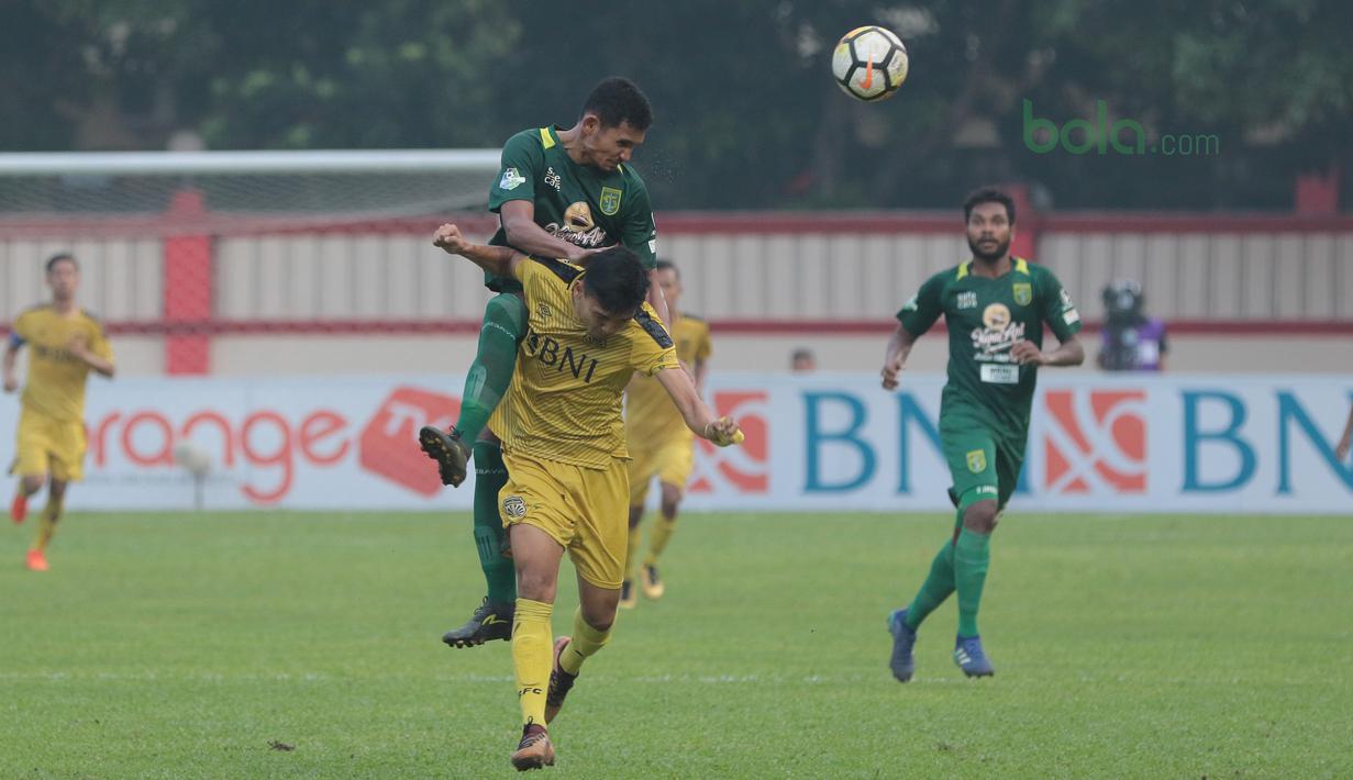 Andri Muladi menghalau bola dari pemain Bhayangkara FC, Dendi Sulistyawan pada laga Gojek Liga 1 bersama Bukalapak di Stadion PTIK, Jakarta, Rabu (11/7/2018). Bhayangkara FC bermain imbang 3-3. (Bola.com/Nick Hanoatubun)