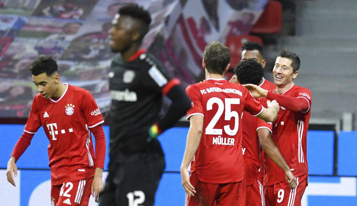Para pemain Bayern Munchen merayakan gol yang dicetak oleh Robert Lewandowski ke gawang Bayer Leverkusen pada laga Bundesliga di Stadion BayArena, Minggu (20/12/2020). Bayern Munchen menang dengan skor 2-1. (Bernd Thissen/Pool Photo via AP)