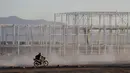 Pekerja mengendarai motor di lokasi proyek pembangunan Pabrik Ford di Villa de Reyes, San Luis Potosi, Meksiko, (4/1). Ford mengumumkan pembatalan pembangunan pabrik baru di negara tersebut. (AP Photo/Rebecca Blackwell)