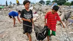 Dua orang anak membawa sisa-sisa besi dari reruntuhan bangunan yang dirobohkan di kawasan Pasar Ikan, Penjaringan, Jakarta, Selasa (12/4). Selain warga, sejumlah pemulung besi berhambur untuk menjarah besi dari bekas bangunan (Liputan6.com/Yoppy Renato)