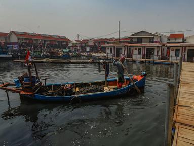 Nelayan membawa kerang hijau usai melaut ke rumahnya yang sudah direnovasi menjadi rumah apung  di Kampung Nelayan Muara Angke, Jakarta Utara, Rabu (14/8/2024). (merdeka.com/Arie Basuki)