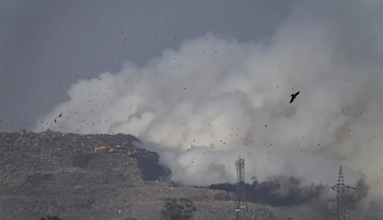 Asap mengepul dari TPA Ghazipur yang sebagian terbakar di pinggiran New Delhi, India (28/3/2022). Kebakaran besar terjadi di tempat pembuangan sampah di daerah Ghazipur Delhi timur yang menyebabkan kepulan asap besar menyelimuti wilayah tersebut dan daerah tetangga. (AP Photo/Altaf Qadri)