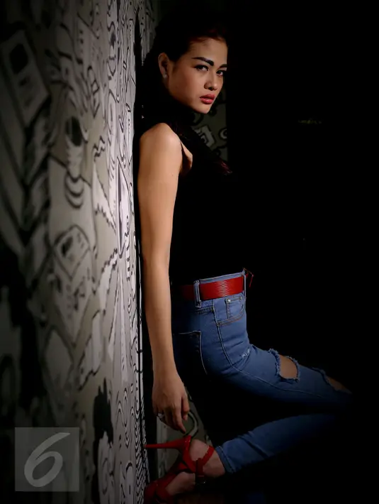 Pose pedangdut Hesty 'Klepek-Klepek' ketika melakukan sesi foto di sebuah studio di Jakarta Pusat, 6 Juli 2015. Saat ditangkap, polisi juga menemukan alat kontrasepsi di kamar hotel wanita kelahiran 19 Mei 1994 itu. (Liputan6.com/Faisal R Syam)