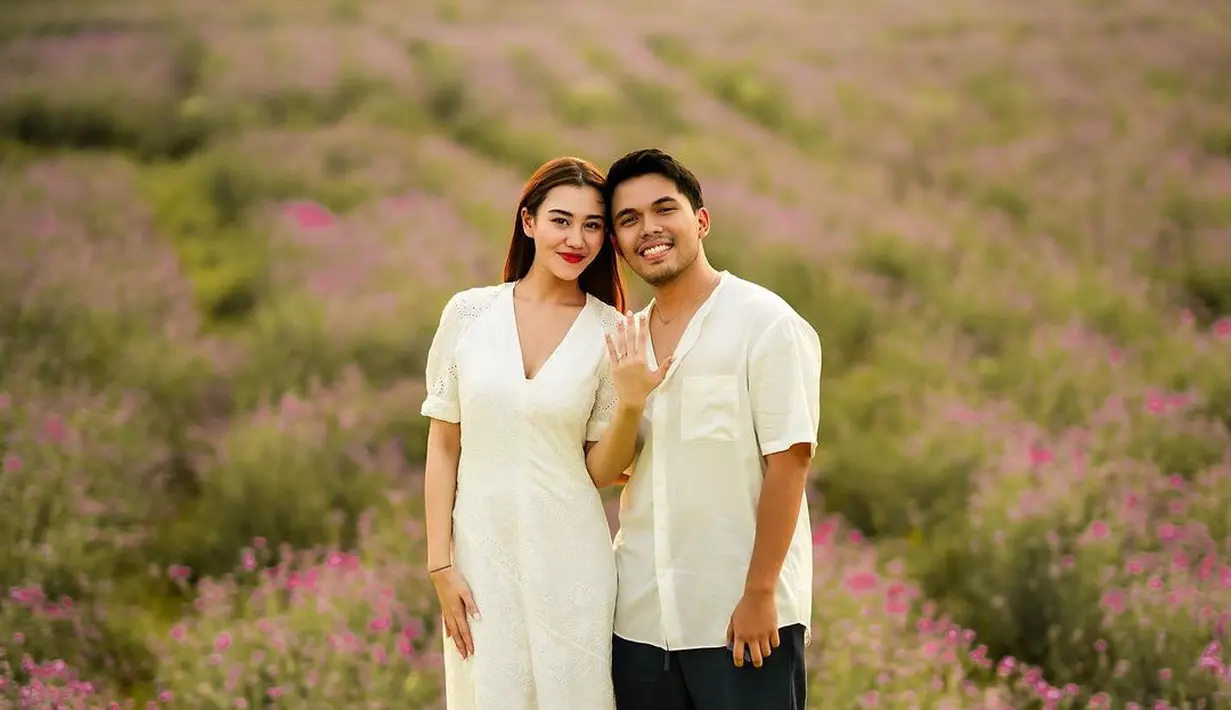 Dengan pemandangan taman bunga menakjubkan, pemotretan lamaran Aaliyah dan Thariq kian spesial dengan penampilan serasi keduanya. Tampak Aaliyah mengenakan dress putih lengan pendek dengan detail garis leher V, sedangkan Thariq dengan kemeja putih dan celana pendeknya. [Foto: Instagram/thariqhalilintar]