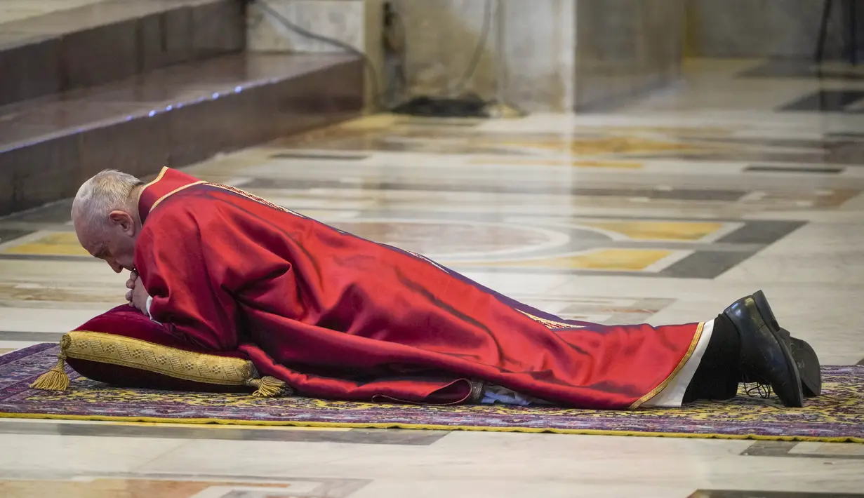 Paus Fransiskus berbaring dalam doa saat memimpin misa Jumat Agung di Basilika Santo Petrus, Vatikan, Jumat (10/4/2020). Pandemi virus corona COVID-19 yang melanda dunia membuat perayaan Jumat Agung berlangsung terbatas untuk menghindari penyebaran penyakit. (AP Photo/Andrew Medichini, Pool)