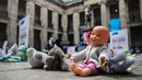 Boneka mainan diletakkan di halaman gedung Kongres Kolombia untuk memprotes kekerasan seksual terhadap anak-anak di Bogota, Selasa (20/11). Protes bertujuan untuk meningkatkan kesadaran tentang tanggung jawab perlindungan anak-anak. (DANIEL MUNOZ/AFP)