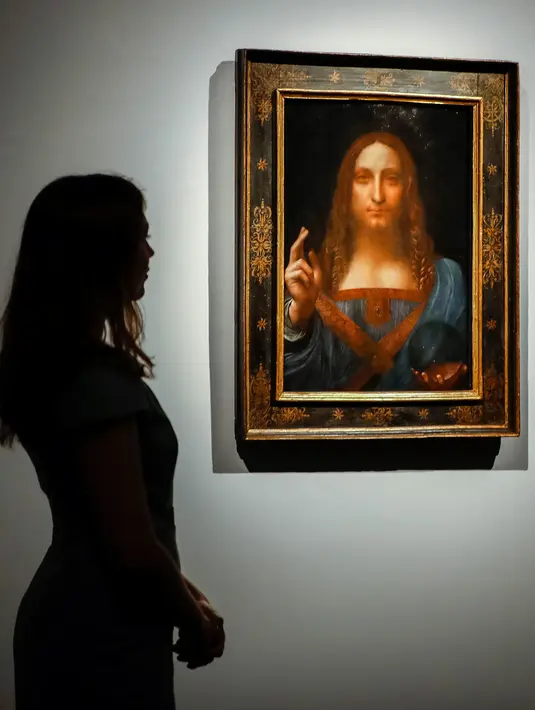 Pekerja melihat lukisan Leonardo da Vinci berjudul 'Salvator Mundi' di rumah lelang Christie di London, (22/10). Diperkirakan, lukisan itu dibuat pada tahun 1500-an. (AFP Photo/Tolga Akmen)
