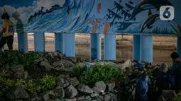 Mural buatan mahasiswa Institut Kesenian Jakarta (IKJ) di kolong Jembatan Pegangsaan, Menteng, Jakarta, Selasa (26/1/2021). Pembuatan mural tersebut merupakan bagian dari pembangunan taman kolong jembatan oleh Pemprov DKI Jakarta. (Liputan6.com/Faizal Fanani)