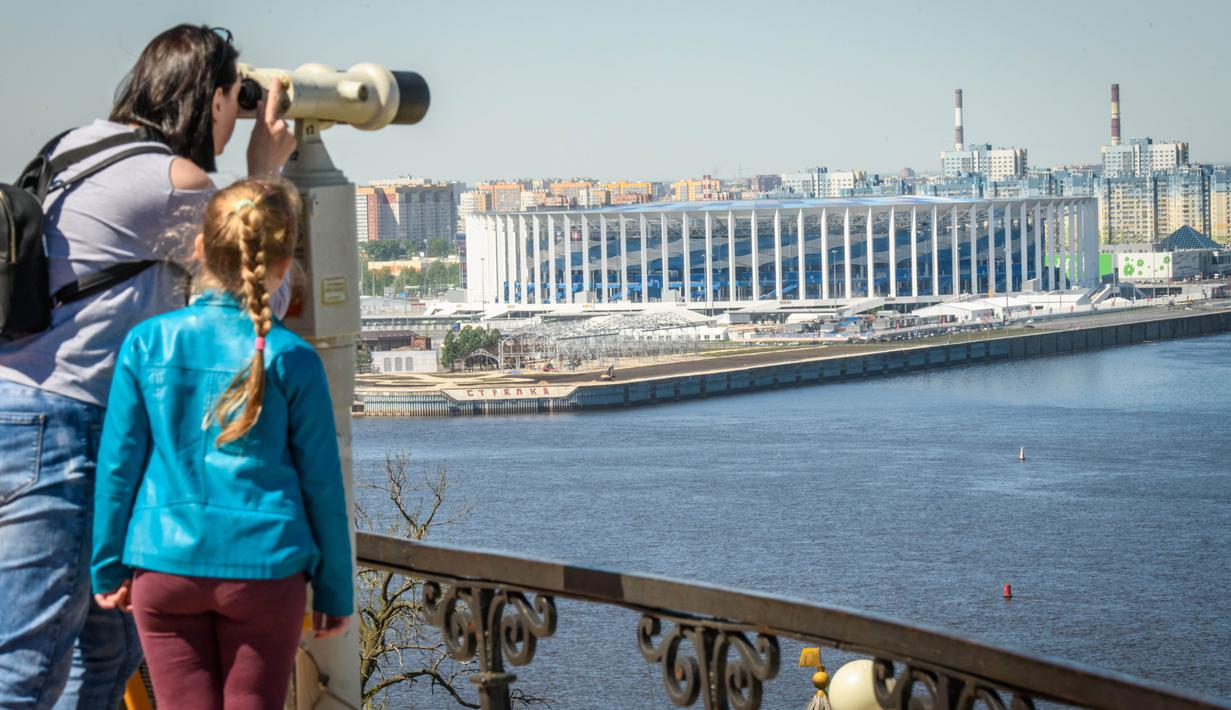 Wisatawan melihat keindahan Nizhny Novgorod Arena dengan terpong di Nizhny Novgorod (21/5/2018). Stadion Novgorod akan menjadi tuan rumah untuk empat pertandingan grup, babak 16 besar dan perempat final. (AFP/Mladen Antonov)