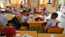 Sementara kegiatan belajar mengajar berlangsung dalam kelas, beberapa orangtua siswa memperhatikan anak mereka dari kejauhan. (Chaideer MAHYUDDIN/AFP)